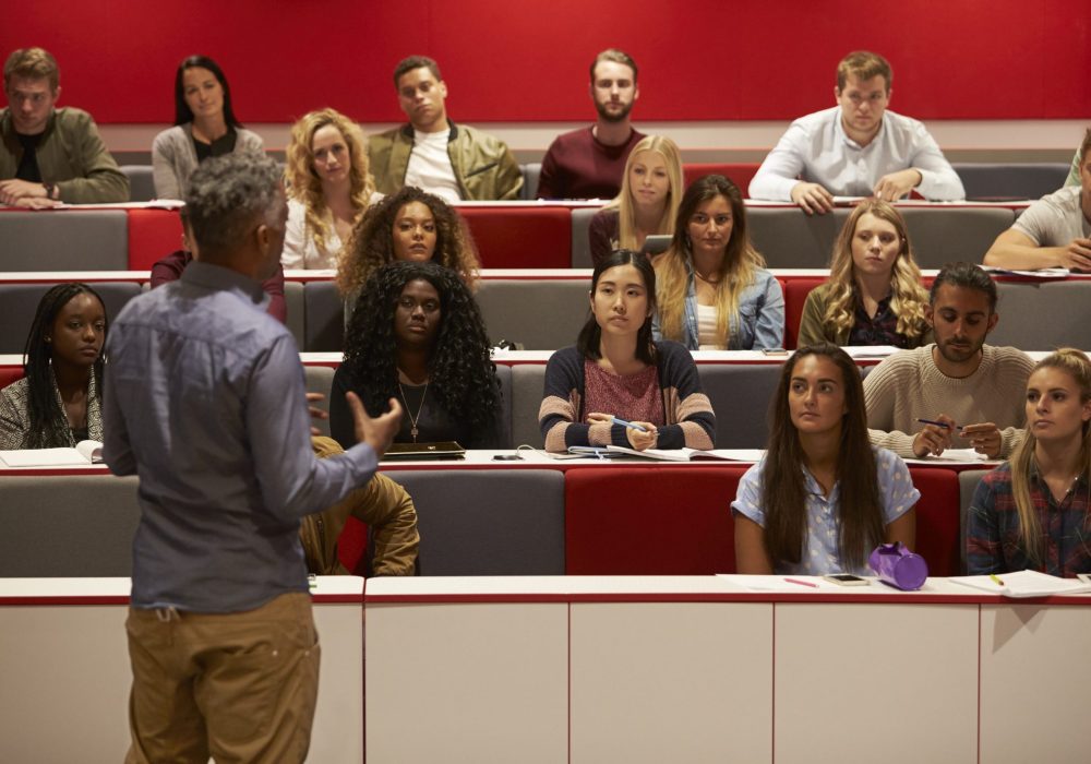 Back View Of Man Presenting To Students At A Lecture