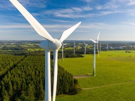 A series of wind turbines in a green field.
