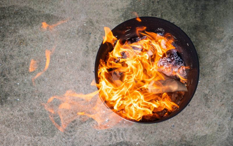 Close Up Paper Burning In Flame. Burning Paper In The Metal Bin.