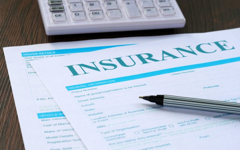 Insurance Form, Calculator And Pen On The Table