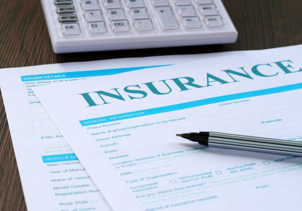 Insurance Form, Calculator And Pen On The Table